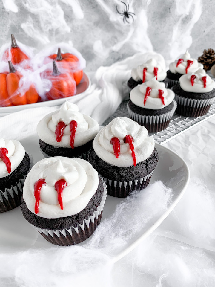These spooky gluten-free and dairy-free vampire bite cupcakes consist of triple chocolate cupcakes filled with strawberry jam topped with blood-bitten vanilla buttercream. Perfect for a Halloween celebration!