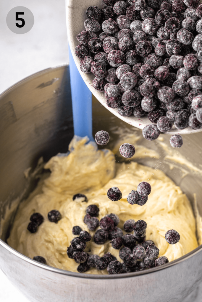 blueberries being tossed into a batter