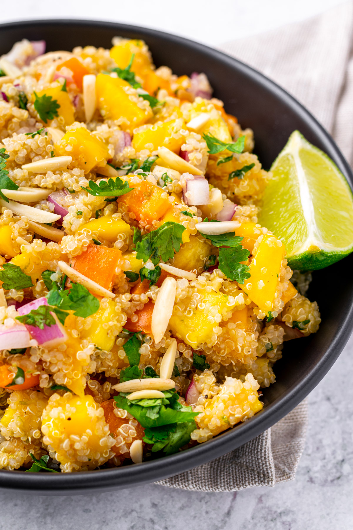 close up of mango pineapple quinoa salad in a large serving bowl