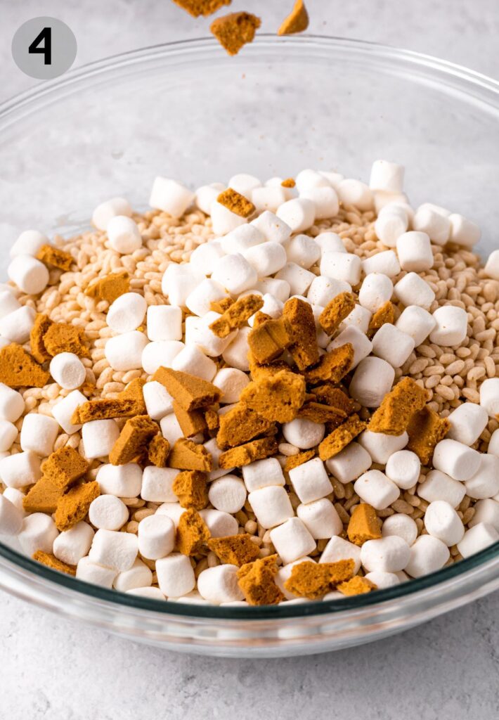 more marshmallows and graham crackers falling into rice crispy mixture