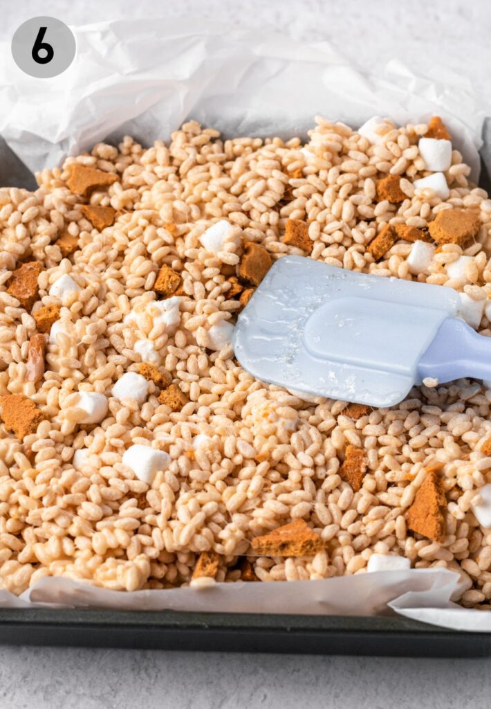 s'mores rice crispy treats being pressed into a baking dish