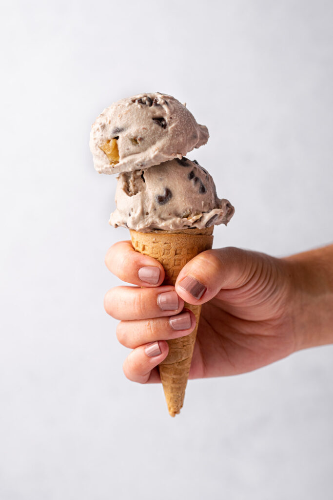 hand holding a cone with vegan chunky monkey scoops