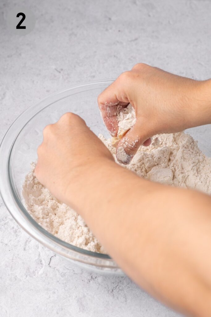 hands cutting butter into scone dough