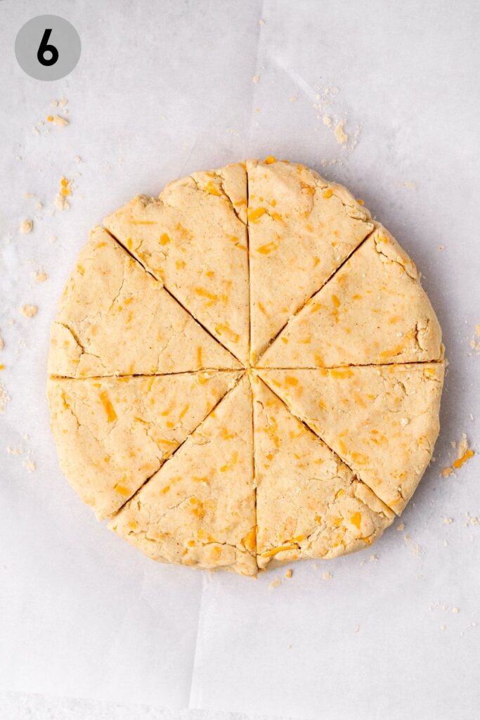 a circle of gluten free cheese scone dough cut into 8 triangles