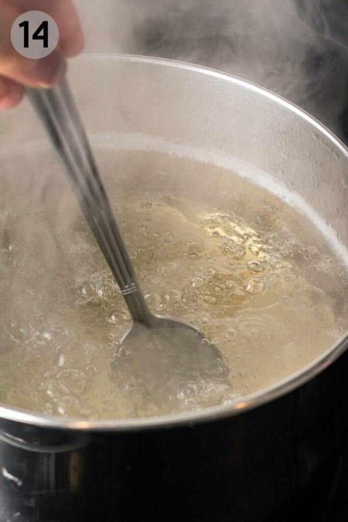 spoon stirring honey into boiling water for bagels