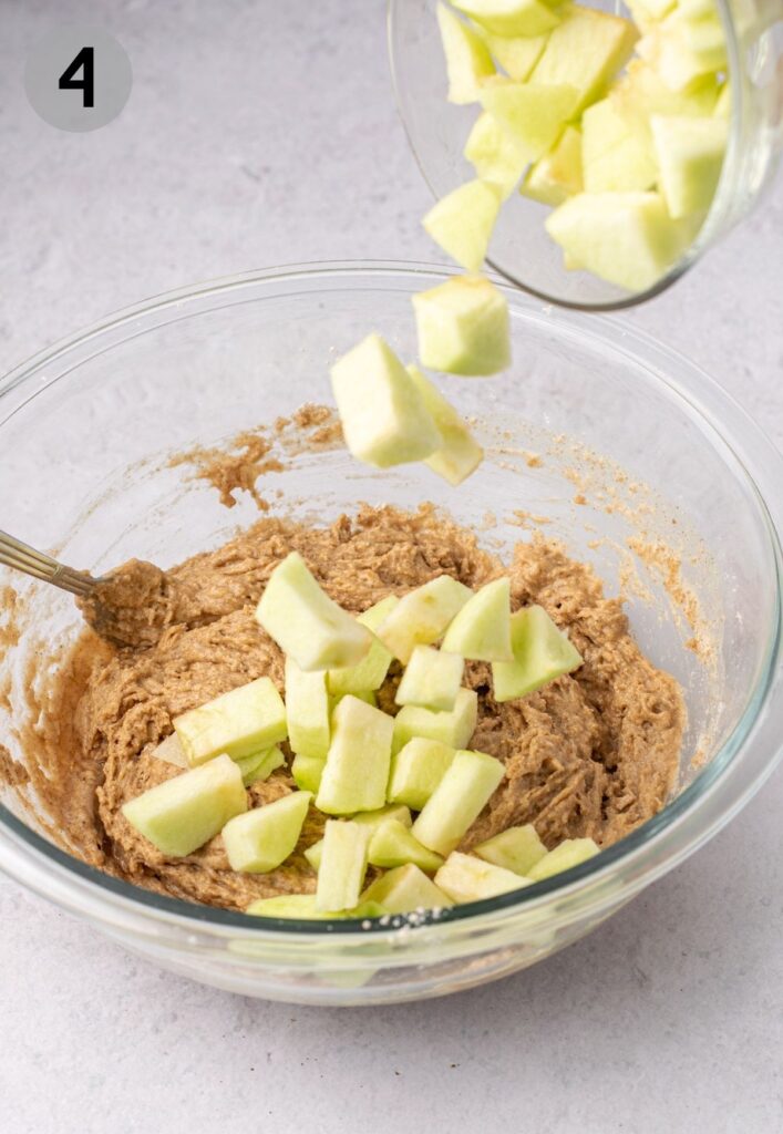 pouring apple cubes into fritter dough