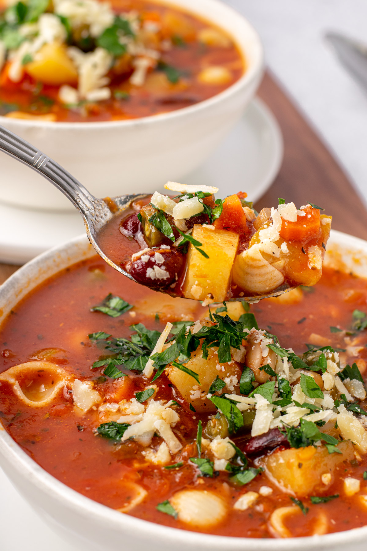 spoon scooping minestrone soup