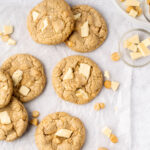 gluten free white chocolate macadamia nut cookies scattered on parchment paper.