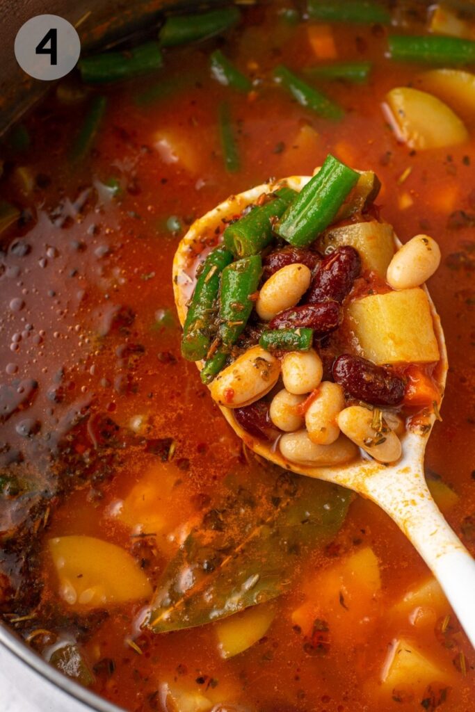 a ladle scooping beans in minestrone soup