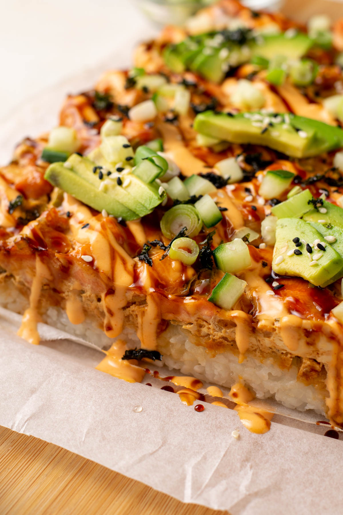 salmon sushi bake topped with avocado and drizzled in spicy mayo.
