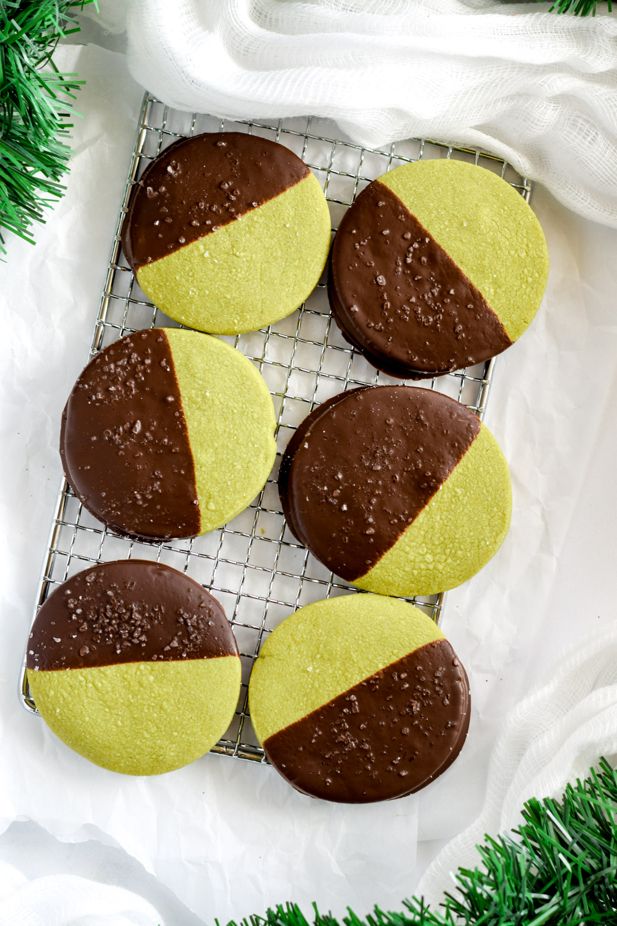 round matcha shortbread cookies half dipped in chocolate.