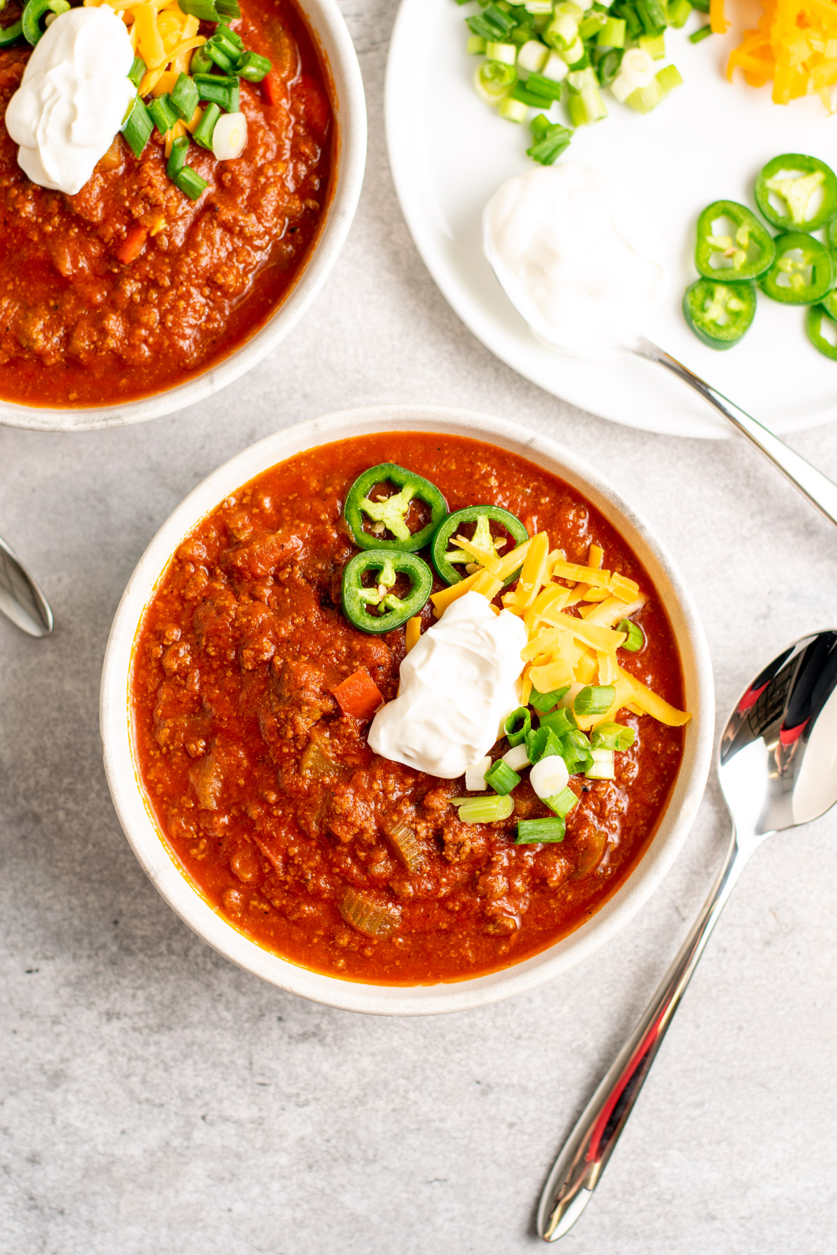 bowls of no bean chili with a plate of garnishes.