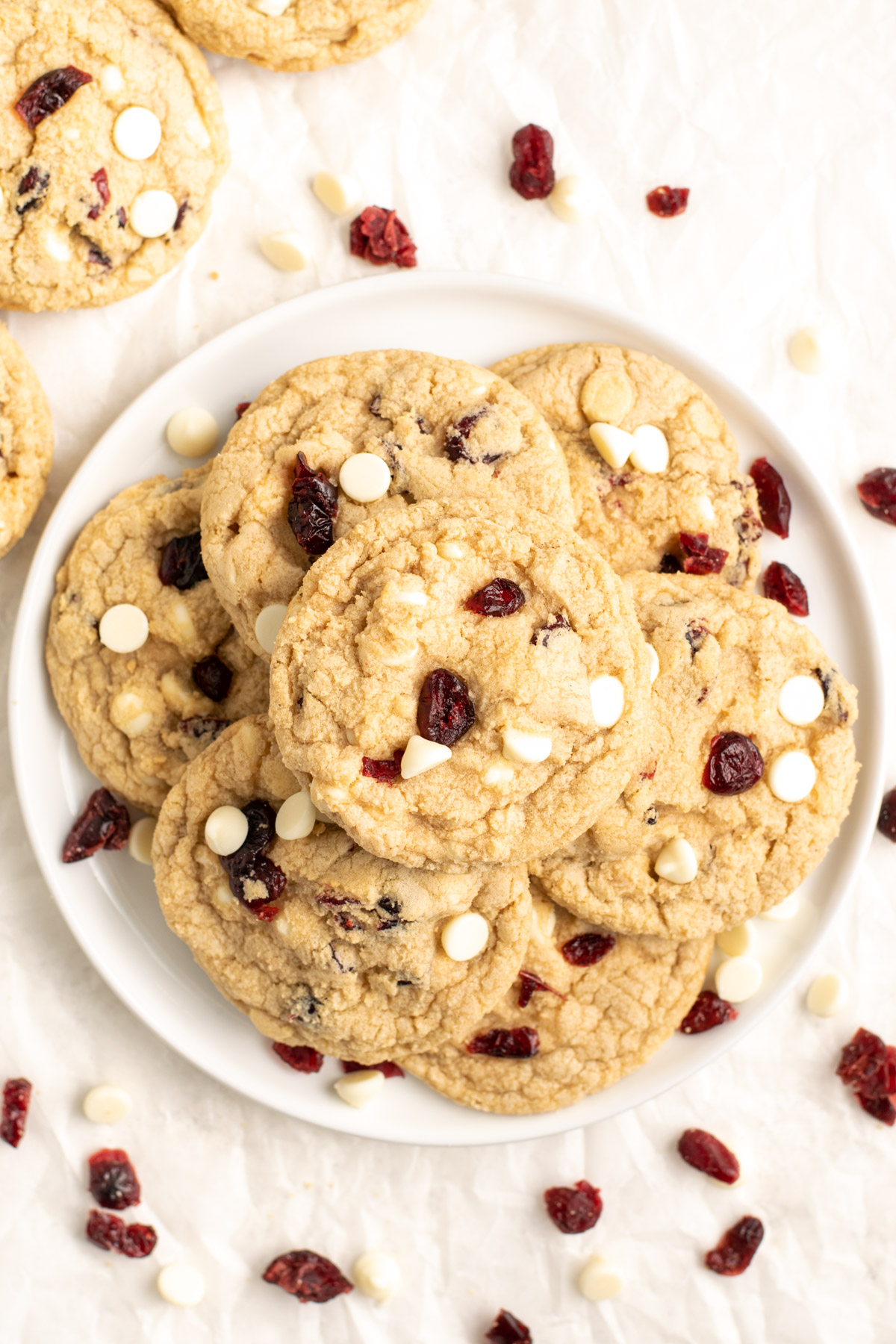 a stack of gluten free white chocolate cranberry cookies on a white plate.